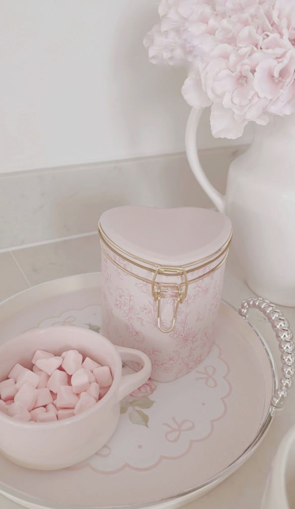 Shabby chic kitchen styling with pink heart marshmallows and a heart shaped hot chocolate tin on a marble countertop by La-Vania